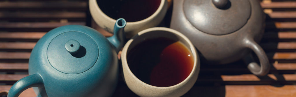 Chinese tea ceremony. Ceramic teapot made of clay and bowls on a wooden background.